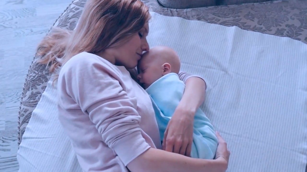 Frau mit Baby auf Bett